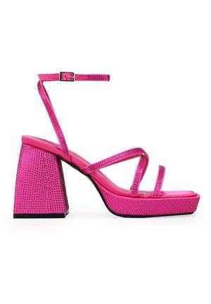 Sandalias de plataforma rosas con tacón bloque y tira en el tobillo, adornadas con strass en la parte superior y el tacón para añadir textura y detalle.