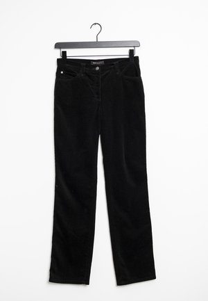Pantalon en velours côtelé noir avec poches avant suspendu sur un cintre noir sur fond blanc.