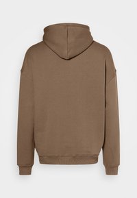 Sudadera marrón hecha de tela suave, presenta capucha, hombros caídos y puños y dobladillo acanalados. Color sólido y sencillo sin patrones.