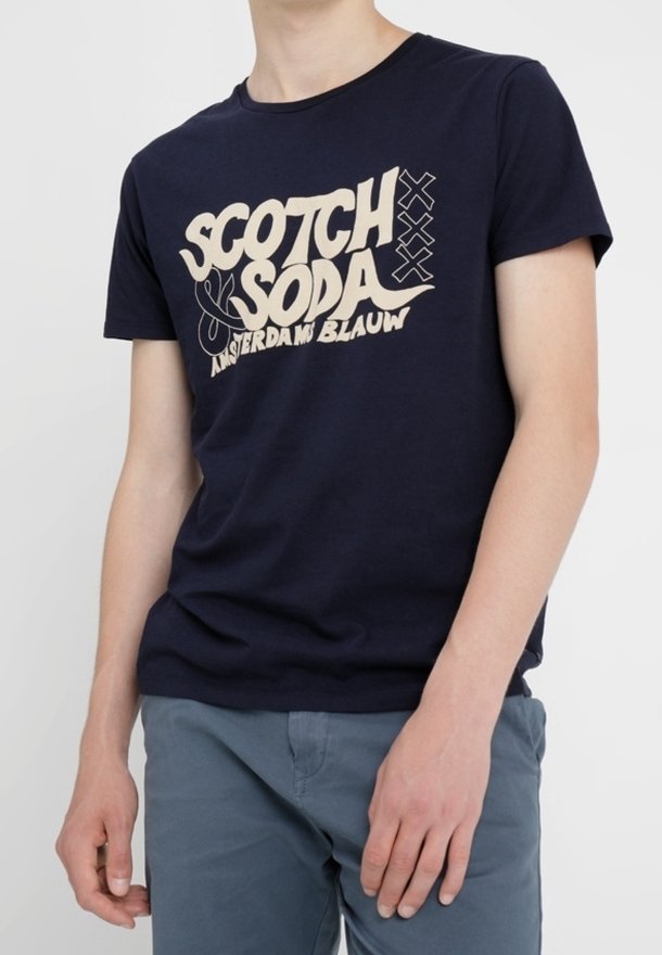 Navyblauwe katoenen T-shirt met een crèmekleurige grafische print met de tekst "Scotch & Soda" en "Amsterdam Blauw". Korte mouwen en ronde hals.