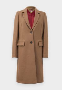Long manteau en laine couleur camel avec col à revers, deux boutons à l'avant, poches à rabat et doublure en satin rouge visible au niveau du col.