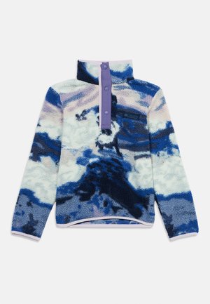 Fleece sweater in navy, blue, and pastel patterns. Features a high collar, half-button closure, and a small logo on the chest. Soft texture.