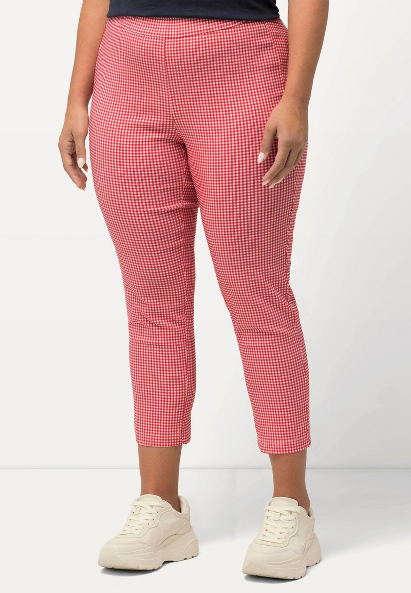 Červené a bílé krátké kalhoty s kostkovaným motivem gingham, přiléhavý střih, elastický pas, kombinované s bílými teniskami pro ležérní vzhled.