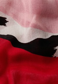 Chusta wzorzysta z wyrazistymi kolorami czarnym, czerwonym i różowym, charakteryzująca się teksturowanym splotem i falującym wzorem. Akcenty nadają jej falisty wygląd.