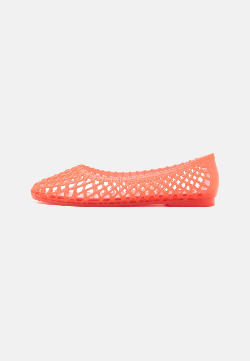 Chaussure plate de couleur corail avec un design en treillis ouvert tissé, réalisée en matériau plastique flexible, vue de profil.
