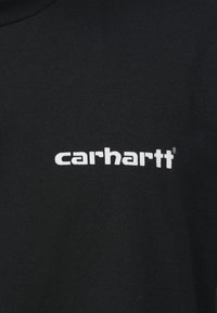 Czarny bawełniany t-shirt z białym logo "carhartt" w pogrubionej czcionce bezszeryfowej, na tle gładkiej faktury tkaniny.