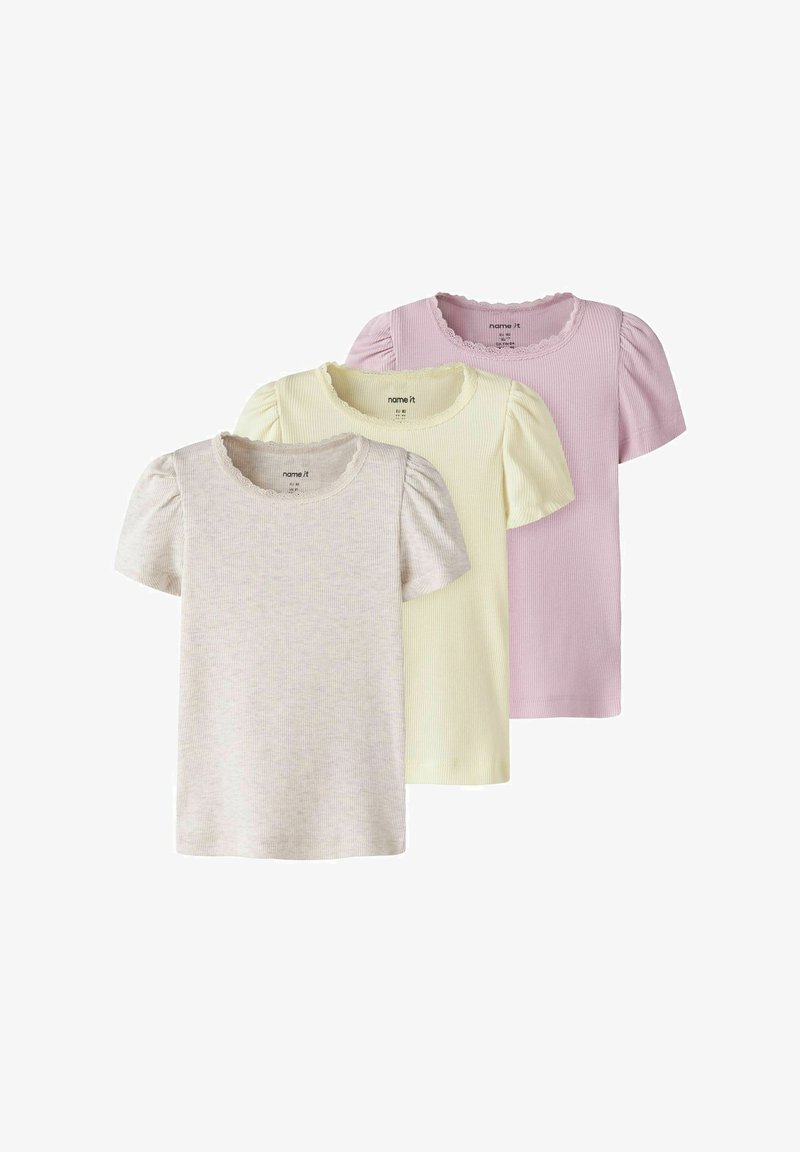 Drie meisjes tops met korte mouwen in ribstof, met pofmouwen en kanten afwerking, in beige, lichtgeel en lichtroze, gestapeld weergegeven.