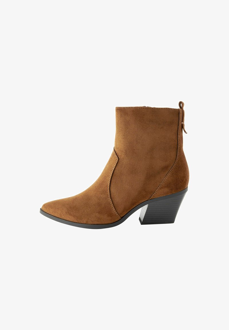 Botín de ante marrón hasta el tobillo con punta puntiaguda, detalle de costura lateral y un tacón negro texturizado. Cuenta con una lengüeta en la parte trasera para facilitar su puesta.
