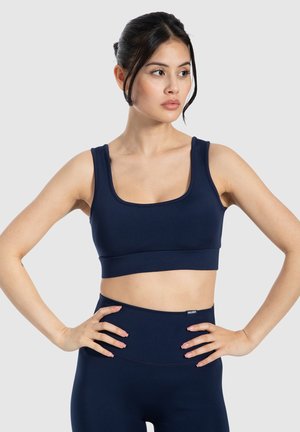Marine sports crop top gemaakt van rekbaar materiaal; heeft brede bandjes en een vierkante halslijn, gecombineerd met high-waisted legging in bijpassende kleur.