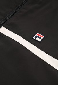Giacca nera con una striscia bianca e logo ricamato. Tessuto liscio e leggero con chiusura a zip. Design sportivo distintivo.