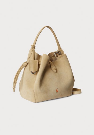 Vaaleanbeige mokkanahkainen säilytyspussilaukku, jossa säädettävä kiristysnaru. Koristeena logovivahde ja irrotettava olkahihna.