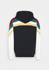 Felpa con cappuccio, con schiena nera, maniche bianche e strisce colorate in rosso, teal, bianco e giallo sulle spalle e sulla parte superiore delle braccia.