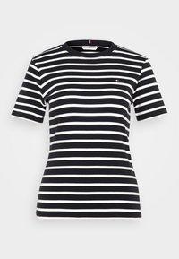 Raidallinen t-paita tummansinisestä ja valkoisesta. Lyhyet hihat, pyöreä kaula-aukko, ribbatusta materiaalista, ja siinä on pieni logo vasemmassa rinnassa.