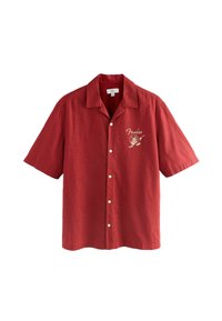 Chemise rouge à manches courtes, à boutons, avec col, texte "Fender" brodé, et personnage de bande dessinée jouant de la guitare sur la poitrine gauche.