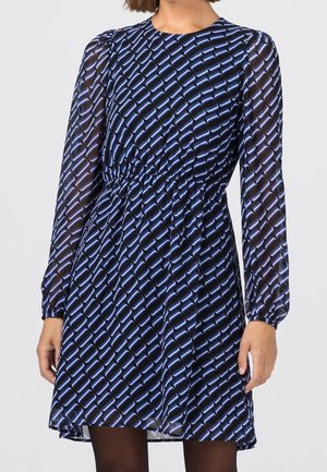 Blau gemustertes Kleid mit langen transparenten Ärmeln, gerafftem Taillenbereich und einem fließenden Rock, der ein geometrisches Design in hellblau auf dunklem Hintergrund zeigt.
