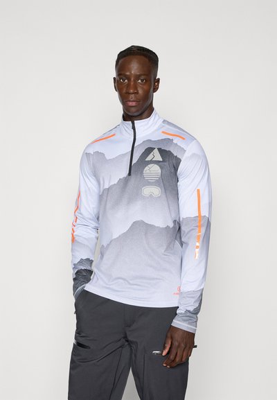 T-shirt de sport à manches longues et col zippé en gris clair avec un design graphique de montagne, des accents orange et un tissu texturé.