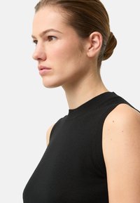 Schwarzes ärmelloses Oberteil mit hohem Ausschnitt, aus glattem Strickmaterial, mit gerippten Akzenten am Ausschnitt und an den Armausschnitten.