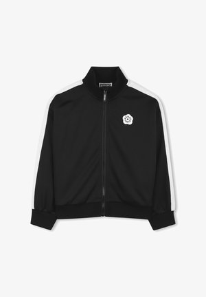 Veste noire à fermeture éclair avec col montant, rayures latérales blanches et logo circulaire sur la poitrine. Fabriquée en tissu lisse avec des poignets côtelés.