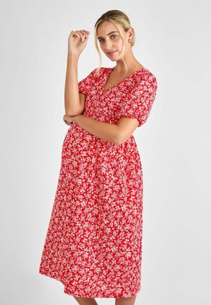 Red floral dress with short sleeves, V-neckline, and a flowing silhouette featuring small white flowers on a textured fabric.