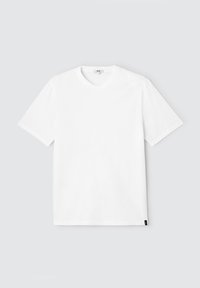 T-shirt blanc à manches courtes en coton, avec un col rond et une petite étiquette noire en bas à gauche. Design simple et uni.