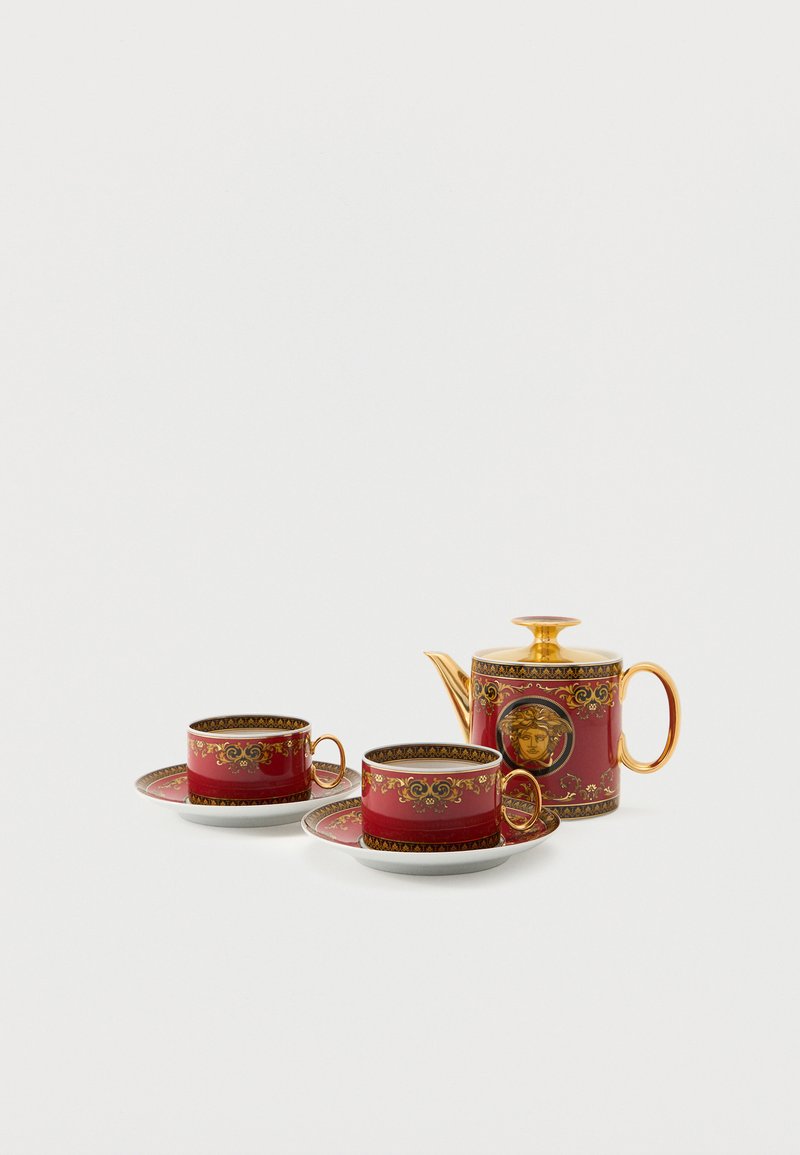 Théière en porcelaine rouge et or accompagnée de deux tasses à thé assorties sur des soucoupes, ornées de motifs baroques complexes et d'un emblème de Méduse.