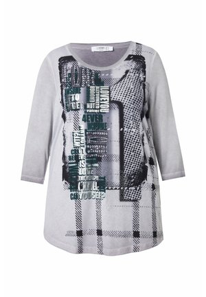 Túnica gris con escote redondo y mangas tres cuartos que presenta texto gráfico y patrones en tonos negros y verdes, con una textura de tela suave.