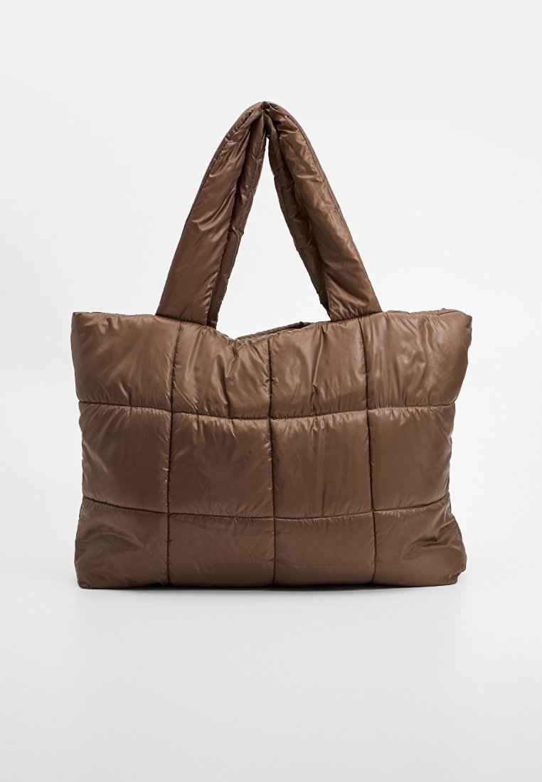 Braune gesteppten Tragetasche mit gepolsterten Griffen, rechteckiger Form und weicher, luftiger Textur vor einem einfarbigen Hintergrund.