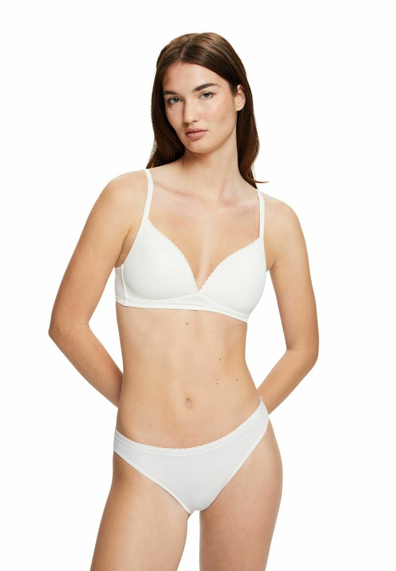 Weißes Wäsche-Set mit einem nahtlosen Bralette mit V-Ausschnitt und gewellten Kanten, kombiniert mit passenden tief sitzenden Slips.
