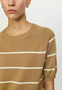 Suéter marrón de punto con rayas horizontales blancas. Presenta un cuello redondo y mangas cortas, ligeramente abullonadas. Material texturizado.