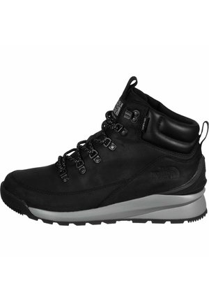 Black mid-height hiking boot with lace-up front, padded collar, gray sole, and "The North Face" logo on side and tongue.