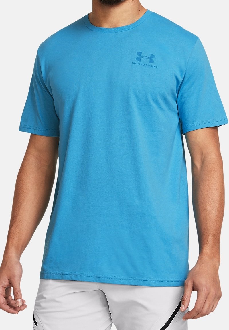 Blå bomullströja med rund hals, korta ärmar och en liten logotyp på övre vänstra bröstet. Mjuk textur, klassisk passform.