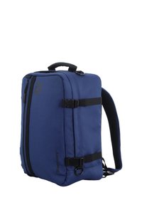 Mochila azul de forma rectangular, hecha de un tejido duradero. Cuenta con un asa superior, correas ajustables y compartimentos con cremalleras negras.