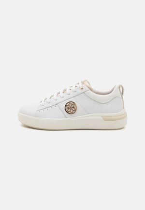 Sneaker bianca con tomaia in pelle testurizzata, dettaglio del logo in hardware dorato e suola spessa beige. Presenta lacci rotondi e collo imbottito.