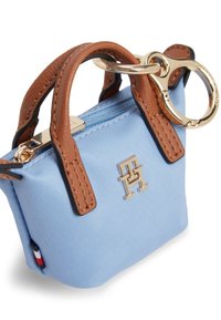 Μπλε τσάντα από ύφασμα με καφέ δερμάτινες λεπτομέρειες, χρυσές μεταλλικές λεπτομέρειες, φερμουάρ κλεισίματος και μικρό κρίκο για μπρελόκ. Διαθέτει λεπτομέρειες με το λογότυπο στην πρόσοψη.