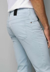 Lichtblauwe slim-fit broek van glad katoen, met twee achterzakken, subtiele stiksels en een zwart logo op de tailleband.