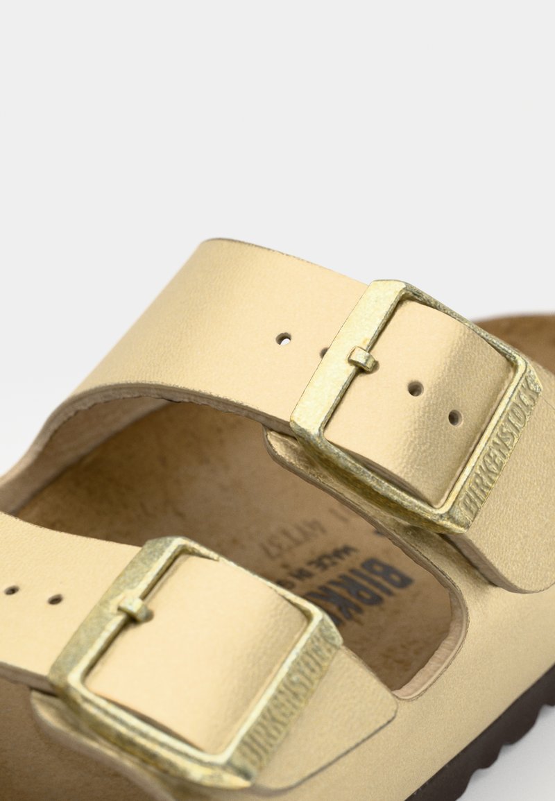 Gelbe Leder-Sandale mit zwei verstellbaren Schnallen, konturiertem Fußbett und strukturiertem Innensole. Gummisohle mit leichter Wölbung.