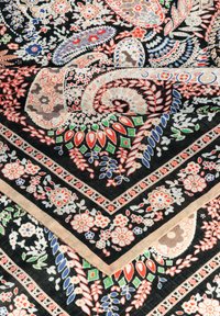 Muster-Schal mit schwarzem Hintergrund und lebendigen Paisley-, Blumen- und geometrischen Designs in Rot, Grün, Blau und Creme.