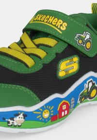 Детска обувка Skechers в зелено и черно с жълти връзки, декорации с трактор и ферма и лепяща се каишка.