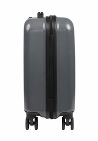 Hård resväska i grått med en glansig yta, svart dragkedja och fyra hjul för smidighet. Minimalistisk design utan logotyper.