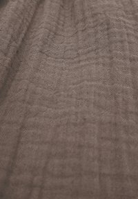 Brauner strukturierten Stoff mit einem Gittermuster und zarter, leichter Webart. Weiche und leicht zerknitterte Erscheinung.