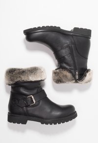 Black leather boots with a chunky sole, faux fur collar, and buckle detail. Side zip closure for easy wear. Textured finish and sturdy design.