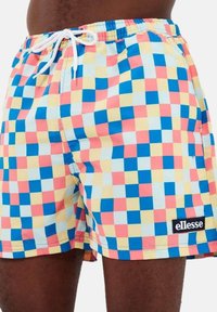 Bañador corto con un patrón de cuadros multicolores que incluye rosa, azul, amarillo y azul claro. Incluye una cinturilla elástica y cordón frontal.