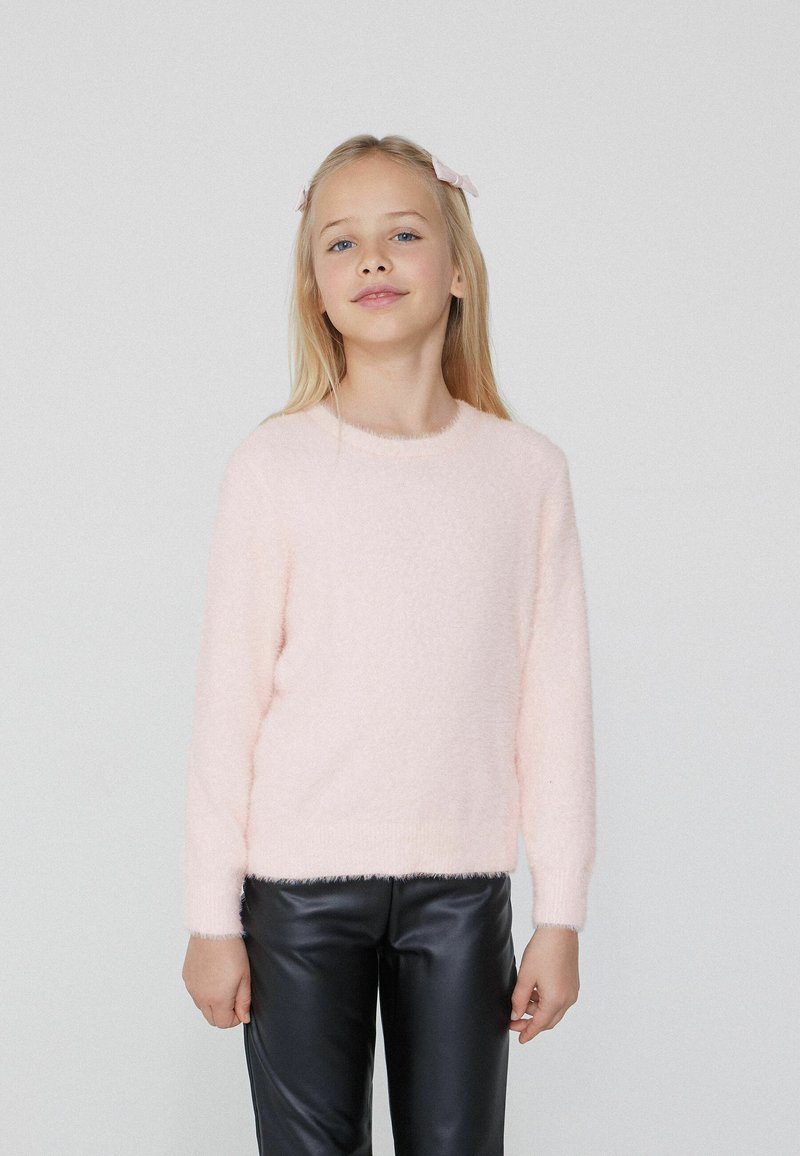 Helles rosa, flauschiges Sweatshirt mit langen Ärmeln, rundem Halsausschnitt und weicher Textur, kombiniert mit schwarzen Kunstlederhosen.