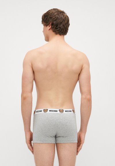 Boxers de algodão cinza com um cós branco que apresenta um logo de urso e o texto "MOSCHINO". Projetados para um ajuste justo.