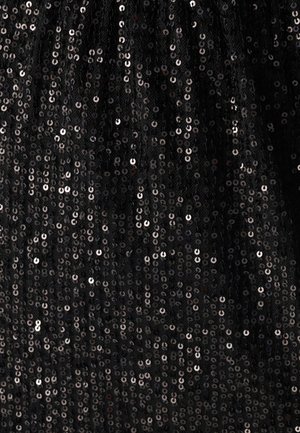 Black fabric covered in circular sequins, reflecting light with a shiny texture. The background appears soft and slightly sheer.