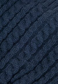 Tessuto di maglia blu navy con motivo a treccia e anelli testurizzati, realizzato con filato morbido che conferisce un aspetto caldo e una sensazione tattile.