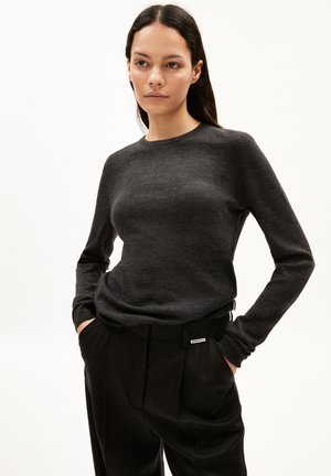 Dunkelgrauer, langärmliger Pullover aus weichem Material, mit rundem Halsausschnitt und lockerem Schnitt, kombiniert mit schwarzen, maßgeschneiderten Hosen.