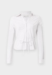 Λευκό πουκάμισο με μακριά μανίκια και ανοιχτόχρωμες κάθετες ρίγες, κλείσιμο με κουμπιά και λεπτομέρεια ζώνης στη μέση. Ύφασμα τραγανό με γιακά και μανίκια με μανσέτες.