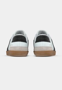 Sneakers con design nero e azzurro chiaro, dettagli in suede e suola in gomma dal colore a contrasto. Presentano un tallone con texture e dettagli del marchio.