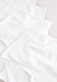 Culottes en coton blanc avec une texture lisse, un design basique et de délicats détails en ruban blanc à la taille.